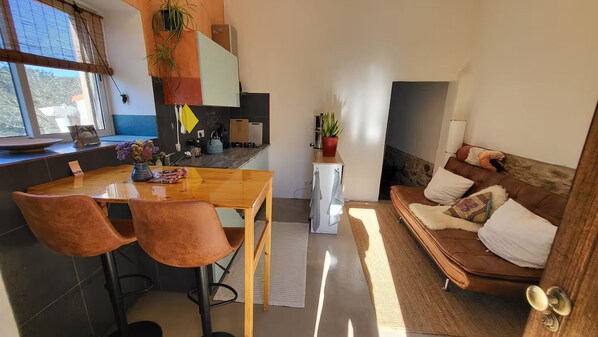 Espaço compacto com área de refeições, cozinha compacta e área de estar.