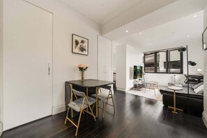 A modern interior with a dining area, a sofa, and a large window. - Stylish Potts Point Apartment | Walk to Kings Cross (City of Sydney)