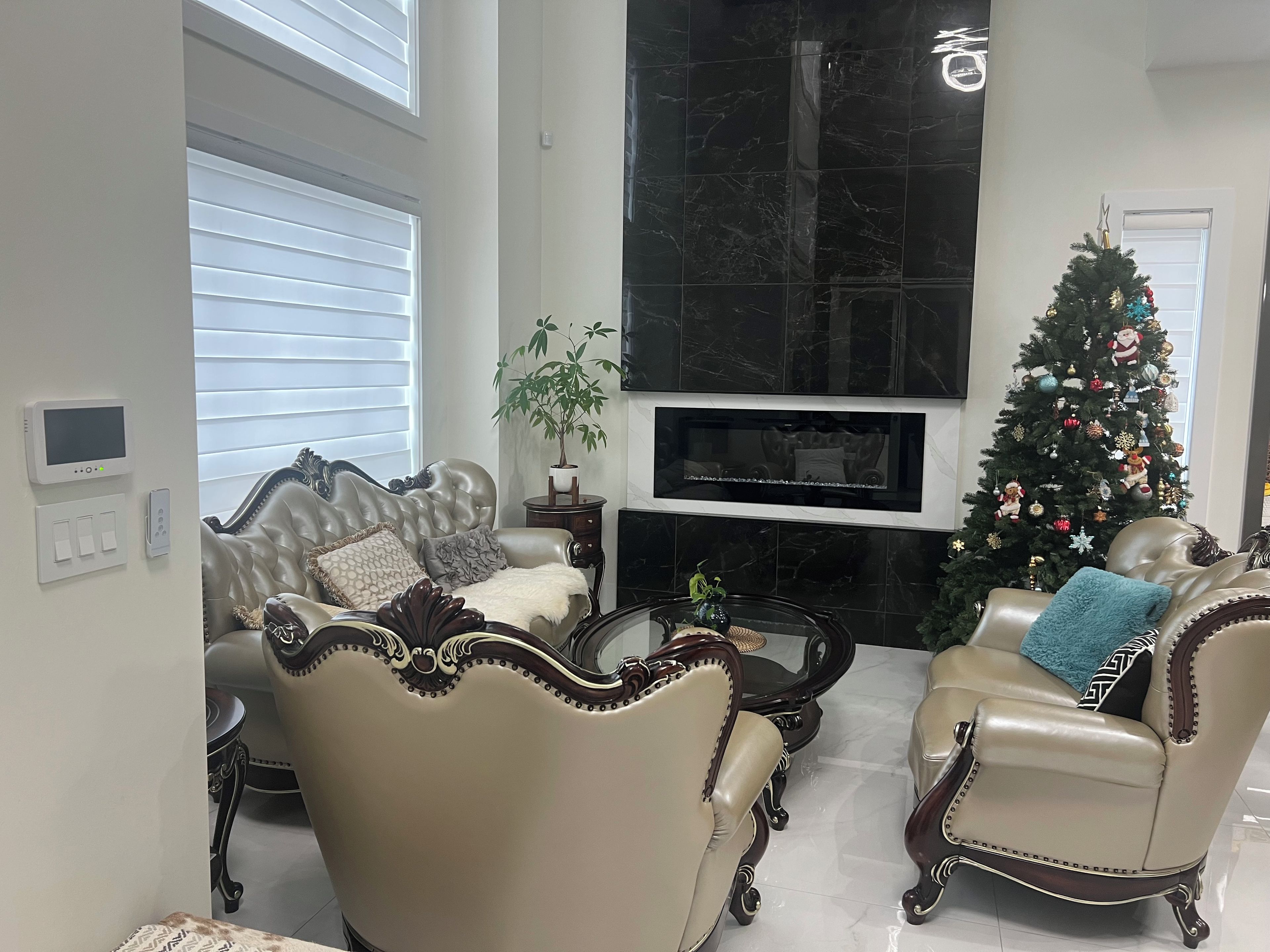 Ein Wohnzimmer mit zwei Ledersesseln, einem Couchtisch, einem Kamin und einem Weihnachtsbaum.