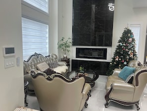 A living room with two leather armchairs, a coffee table, a fireplace, and a Christmas tree. - MEhome’s rental #1, best home short term rental (Richmond)