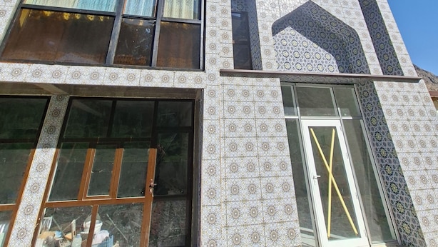 Un edificio de dos pisos con amplias ventanas y paredes de baldosas con diseño.