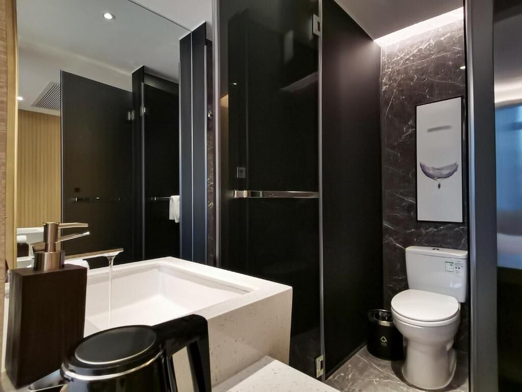 A modern bathroom with a large bathtub, a separate shower area, and a toilet.