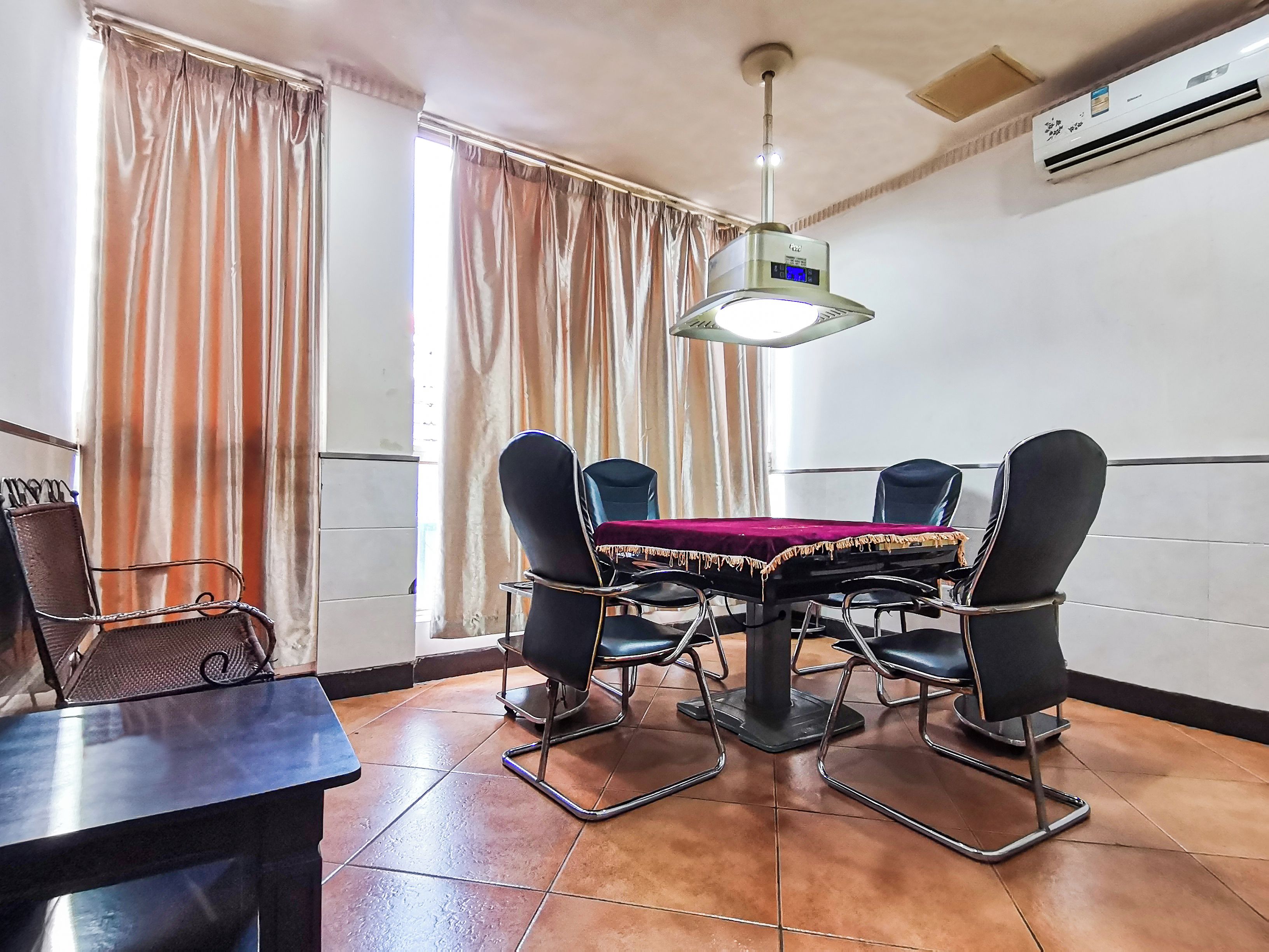 A conference room with a table, chairs, and a ceiling light fixture.