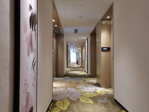 A hotel corridor with a floral carpet, wooden walls, and a sign indicating room number 246. - Paco Hotel Beijing Road Metro Guangzhou (Guangzhou)