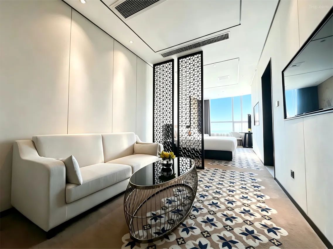 Un salon moderne avec un canapé, une table basse ronde et un tapis à motifs.