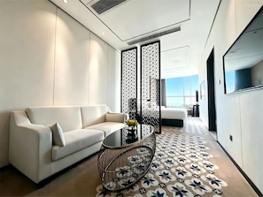 A modern living room with a sofa, a round coffee table, and a patterned carpet.