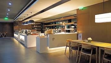 A modern cafe with a bar area, seating, and a visible menu board.