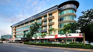 A multi-story hotel with a prominent curved corner and signage indicating it is a PAGO HOTEL.