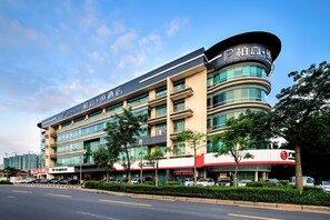 A multi-story hotel with a prominent curved corner and signage indicating it is a PAGO HOTEL.