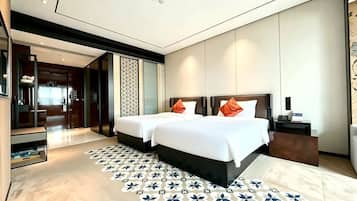 A modern hotel room with a large bed, a bedside table, and a patterned rug.