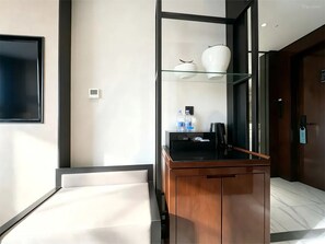 A modern bathroom with a glass shower enclosure, a wooden vanity, and a mounted toilet.