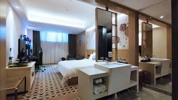 A hotel room with a bed, two sinks, a large mirror, a desk, and a chair.
