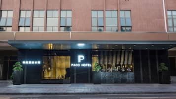 Ein Hotel Eingang mit einer modernen Fassade, einem gut sichtbaren Schild 'Paco Hotel' und einem vergitterten Eingang.