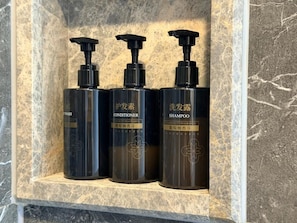 Three black bottles with pump dispensers, labeled as 'Conditioner,' 'Shampoo,' and 'Washing Liquid,' in a marble shelf. - Paco Hotel Shuyin Road Guangzhou (Guangzhou)
