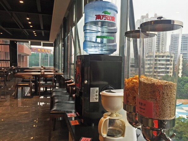 A café interior with seating, a water dispenser, and a coffee machine.