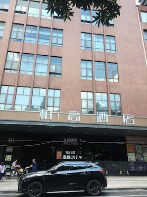 A hotel with a modern facade, multiple windows, and a signboard with text. - Paco Hotel Shuyin Road Guangzhou (Guangzhou)