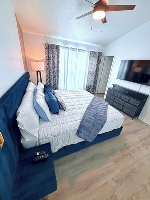 A bedroom with a bed, a TV, a ceiling fan, and a window with curtains. - Disney Family Home/3-bedroom townhome with private pool in Kissimmee. (Kissimmee)