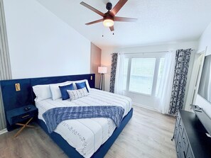 A bedroom with a bed, a nightstand, a dresser, a ceiling fan, and a window with blinds. - Disney Family Home/3-bedroom townhome with private pool in Kissimmee. (Kissimmee)