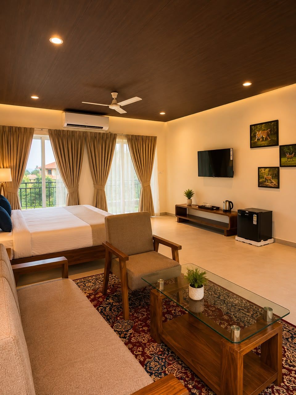 A hotel room with a bed, seating area, TV, and artwork on the wall.