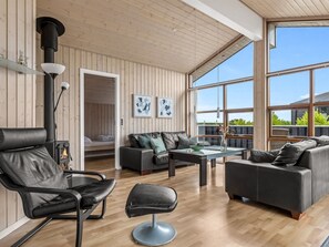 Ein modernes Wohnzimmer mit Kamin, Ledermöbeln und großen Fenstern.