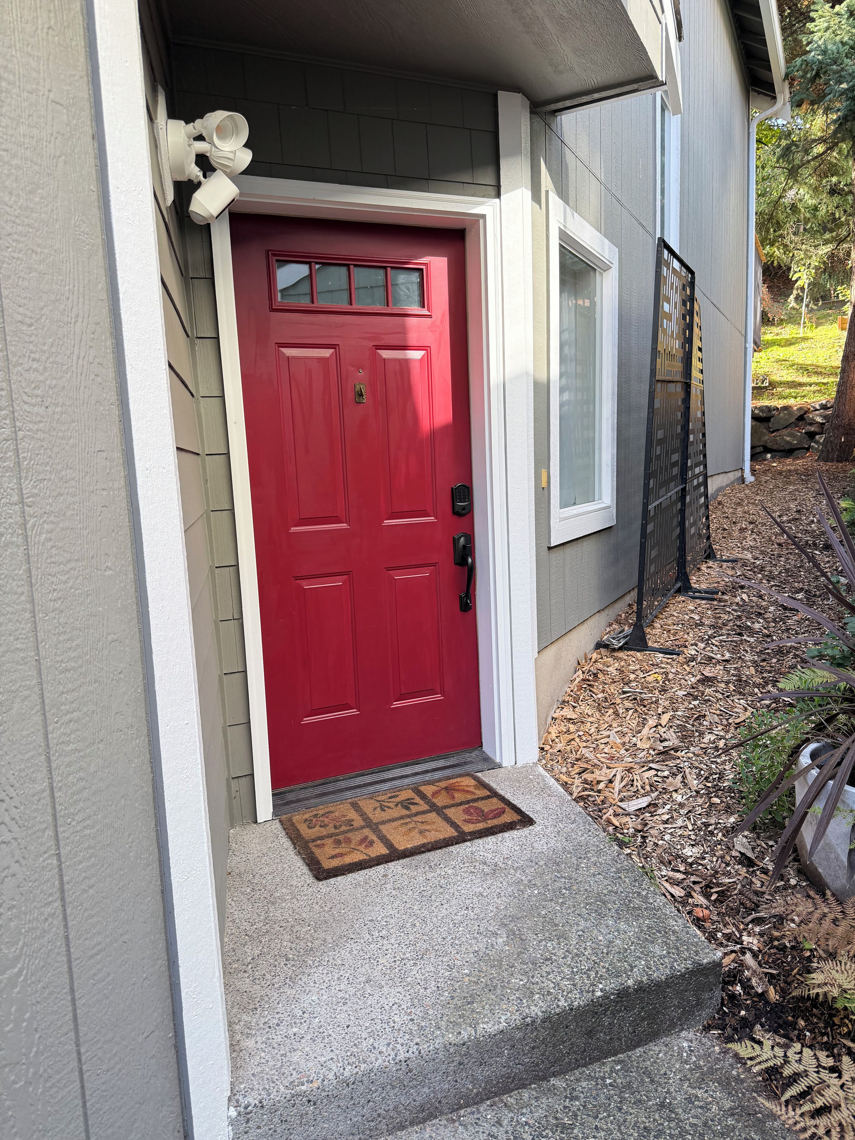 A red door with a mailbox and a doormat.