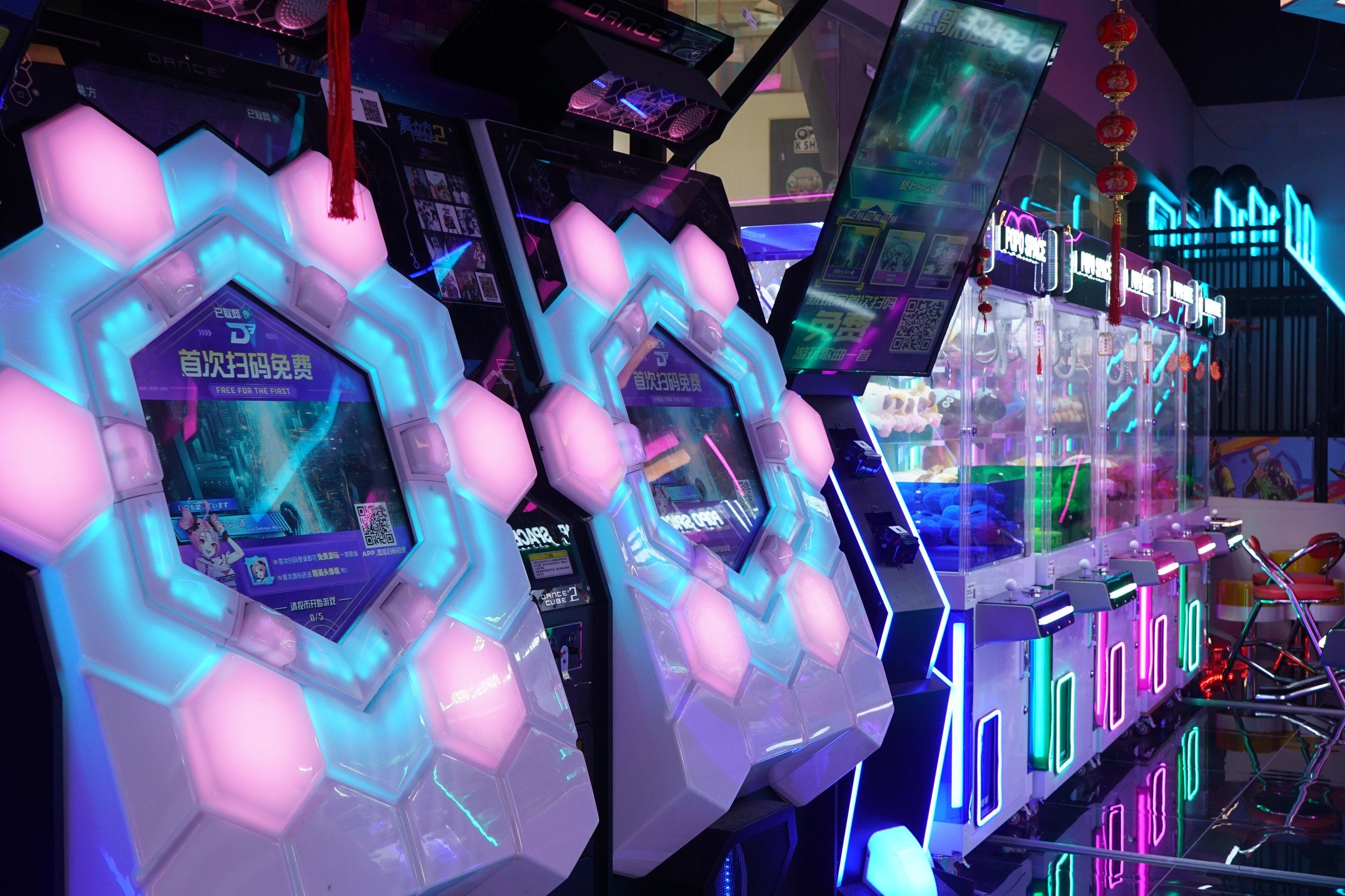 Una hilera de máquinas de juego con formas hexagonales iluminadas y pantallas digitales.