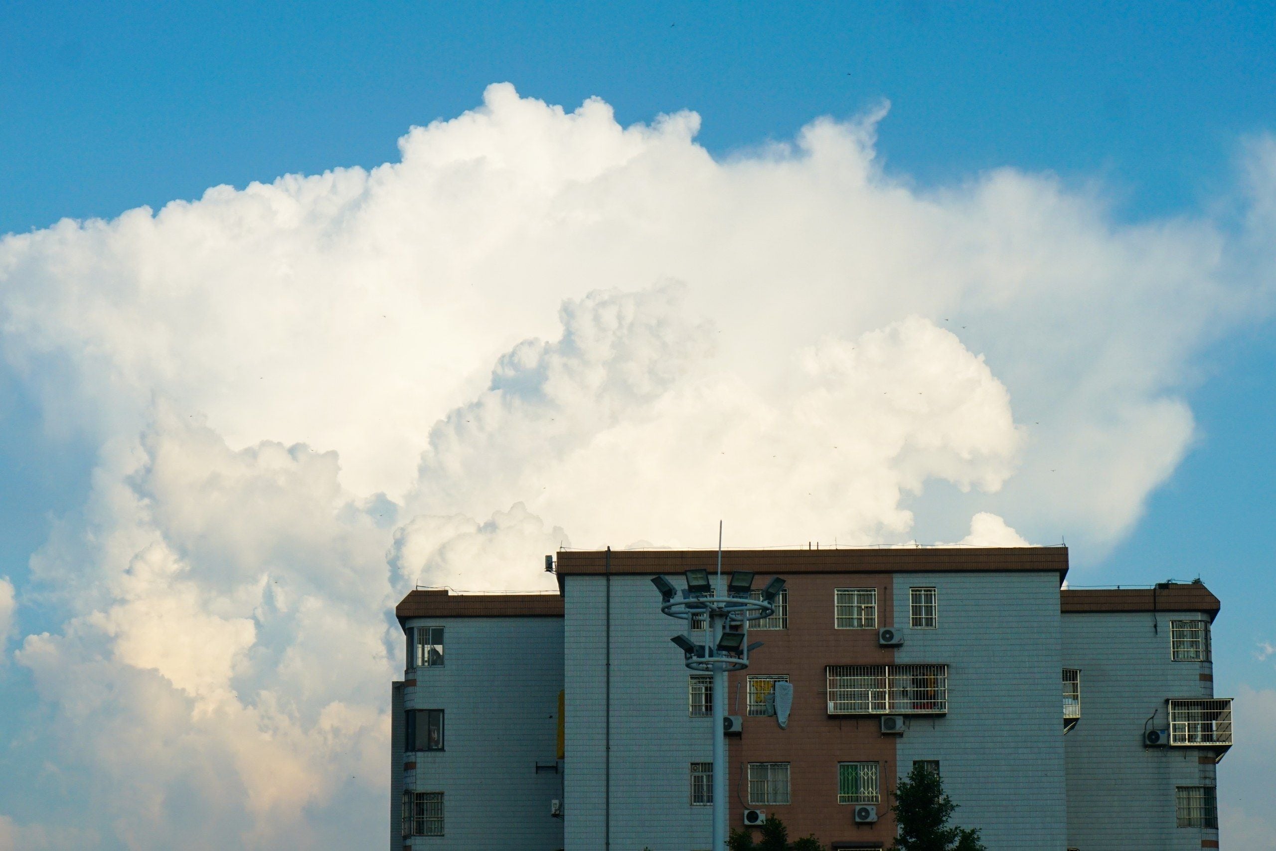 Un edificio con varias ventanas y una gran nube en el cielo.