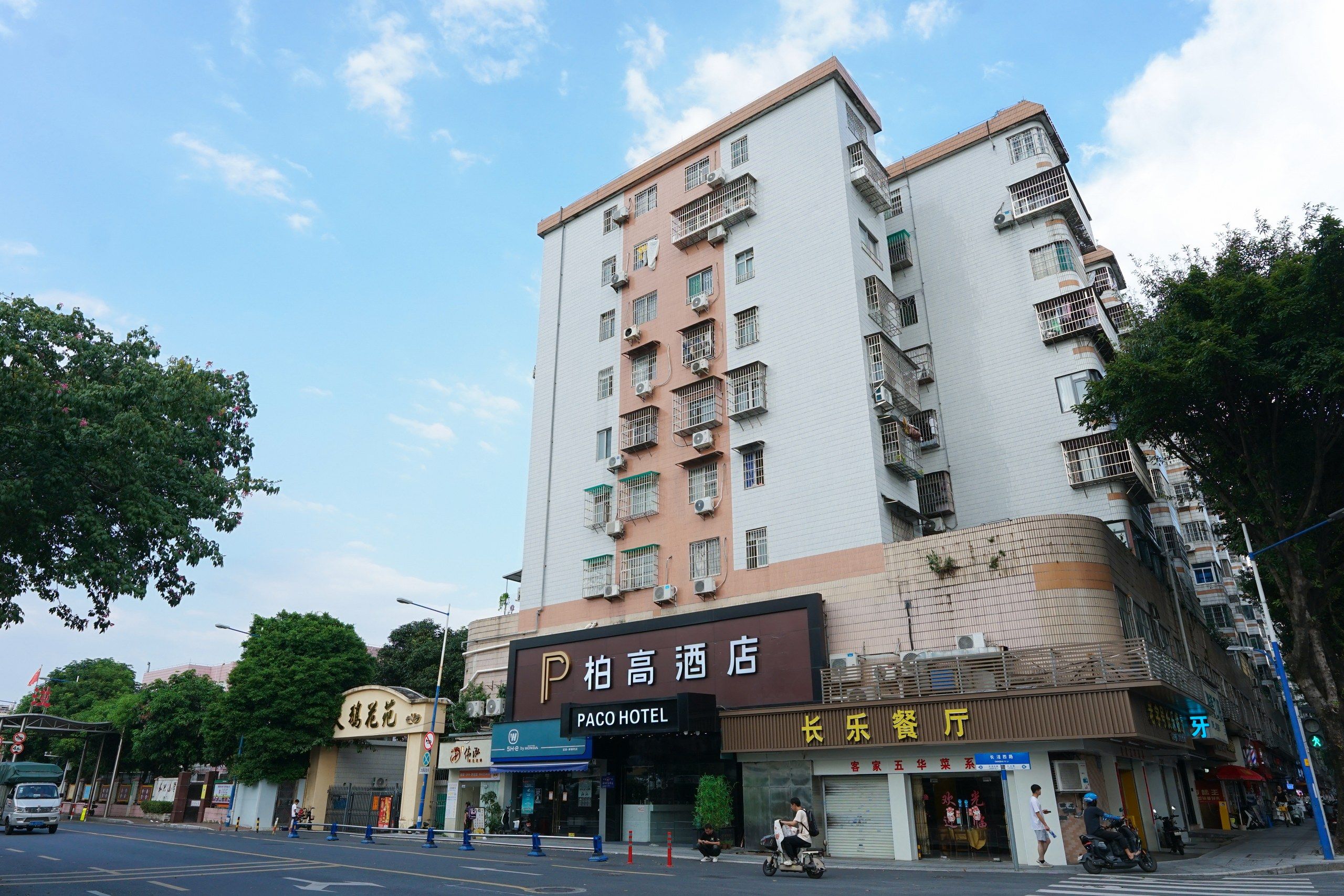 Un edificio de varios pisos con un hotel llamado 'Paco Hotel' en la planta baja.