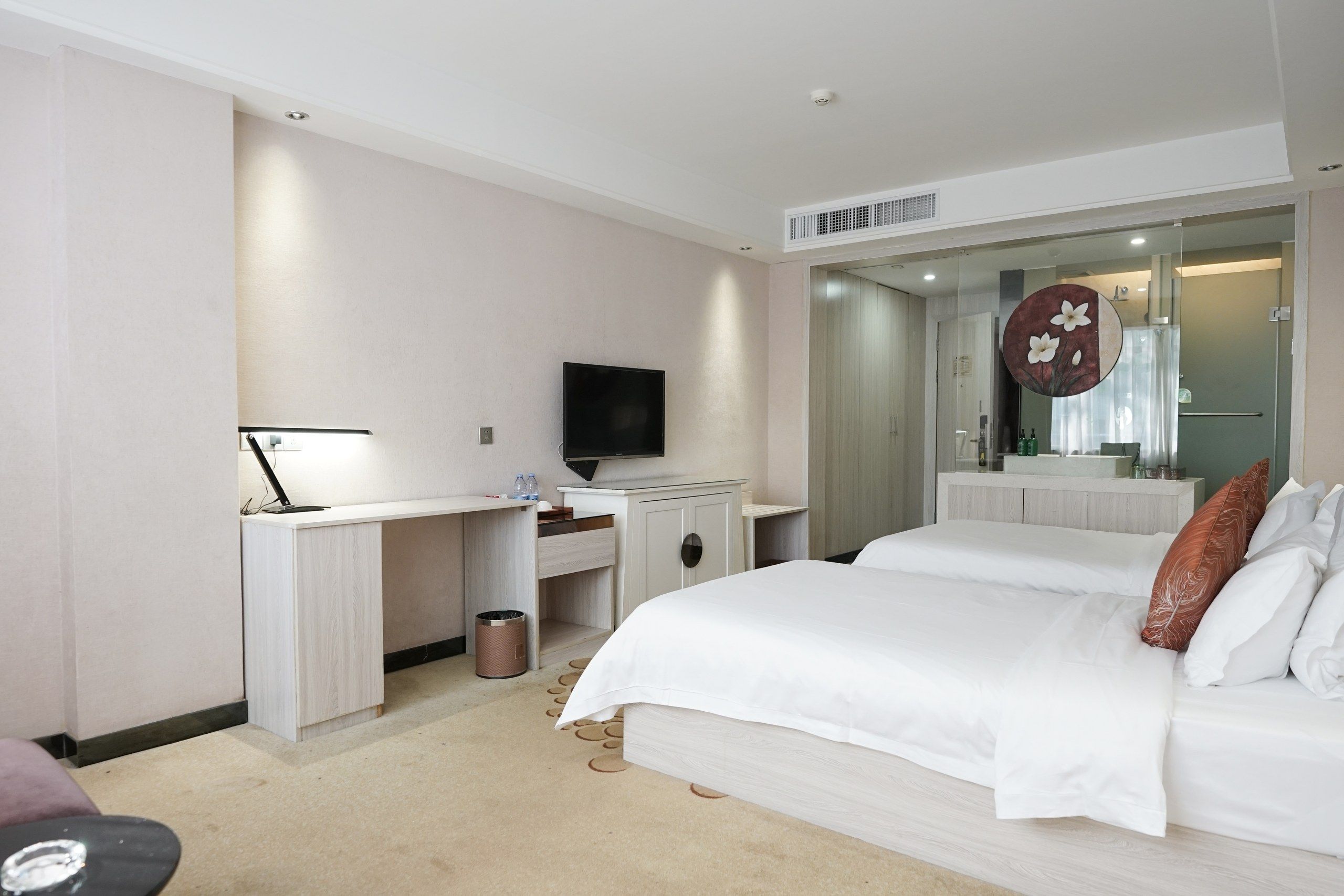 Une chambre d’hôtel comprenant un lit, un bureau avec un ordinateur, une télévision et une salle de bain avec un miroir.