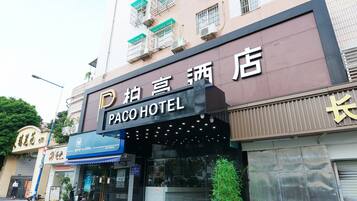 Un hotel con un letrero que dice 'Paco Hotel' y un toldo azul.