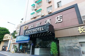 A hotel with a sign that reads 'Paco Hotel' and a blue awning.