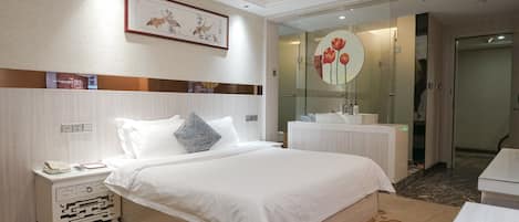 Habitación de hotel con cama, mesita de noche y espejo decorado con motivos florales.