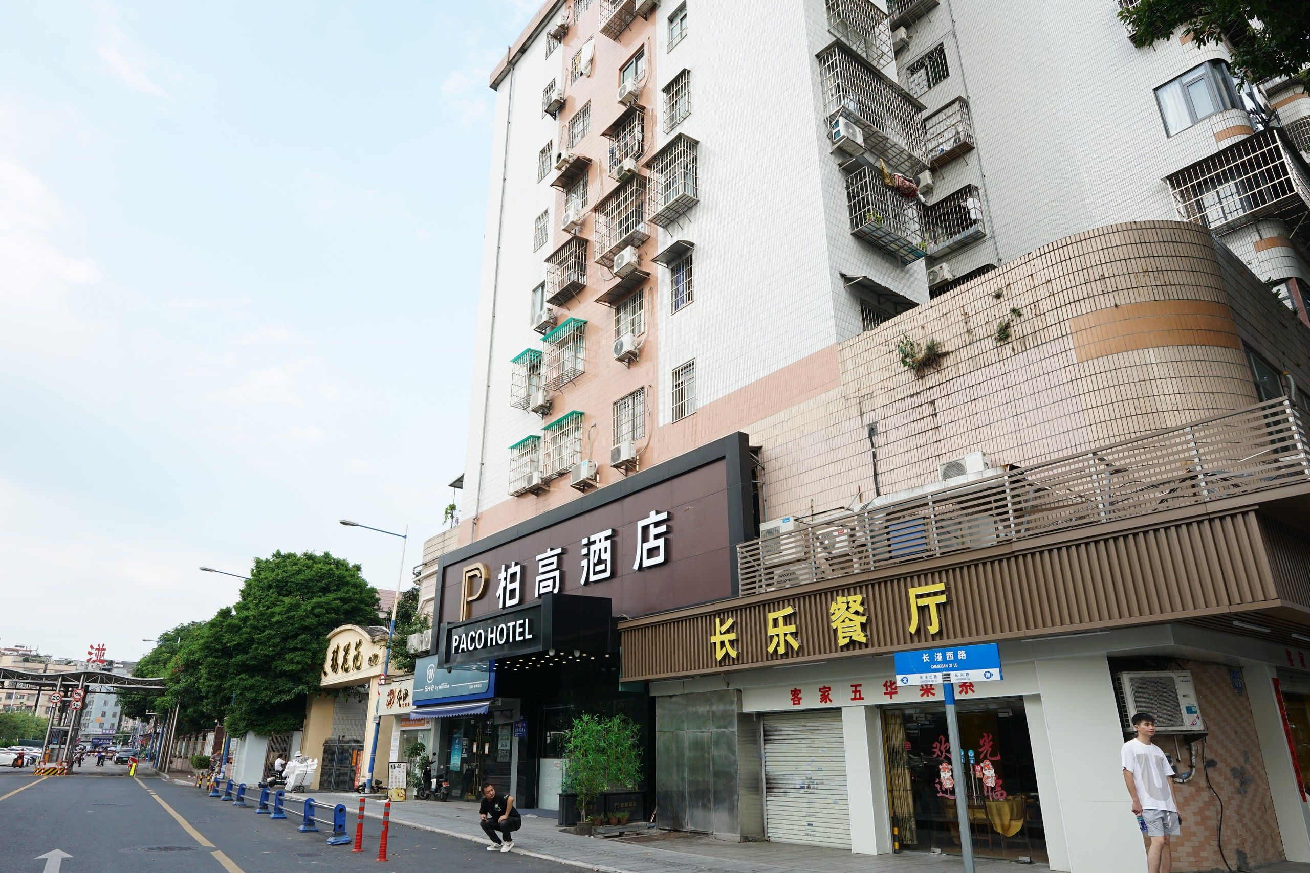 A multi-story building with a hotel named 'Paco Hotel' on the ground floor.