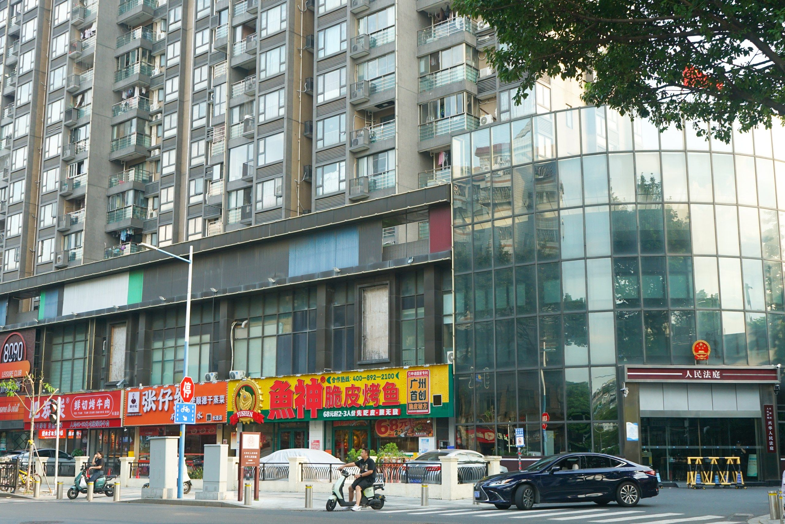 Un edificio de varios pisos con locales comerciales en la planta baja, incluyendo un restaurante y un club.