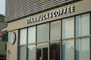 A Starbucks Coffee storefront with a large sign, a logo, and a glass entrance.
