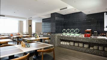 Un restaurante moderno con mostrador, asientos y zona de cocina.