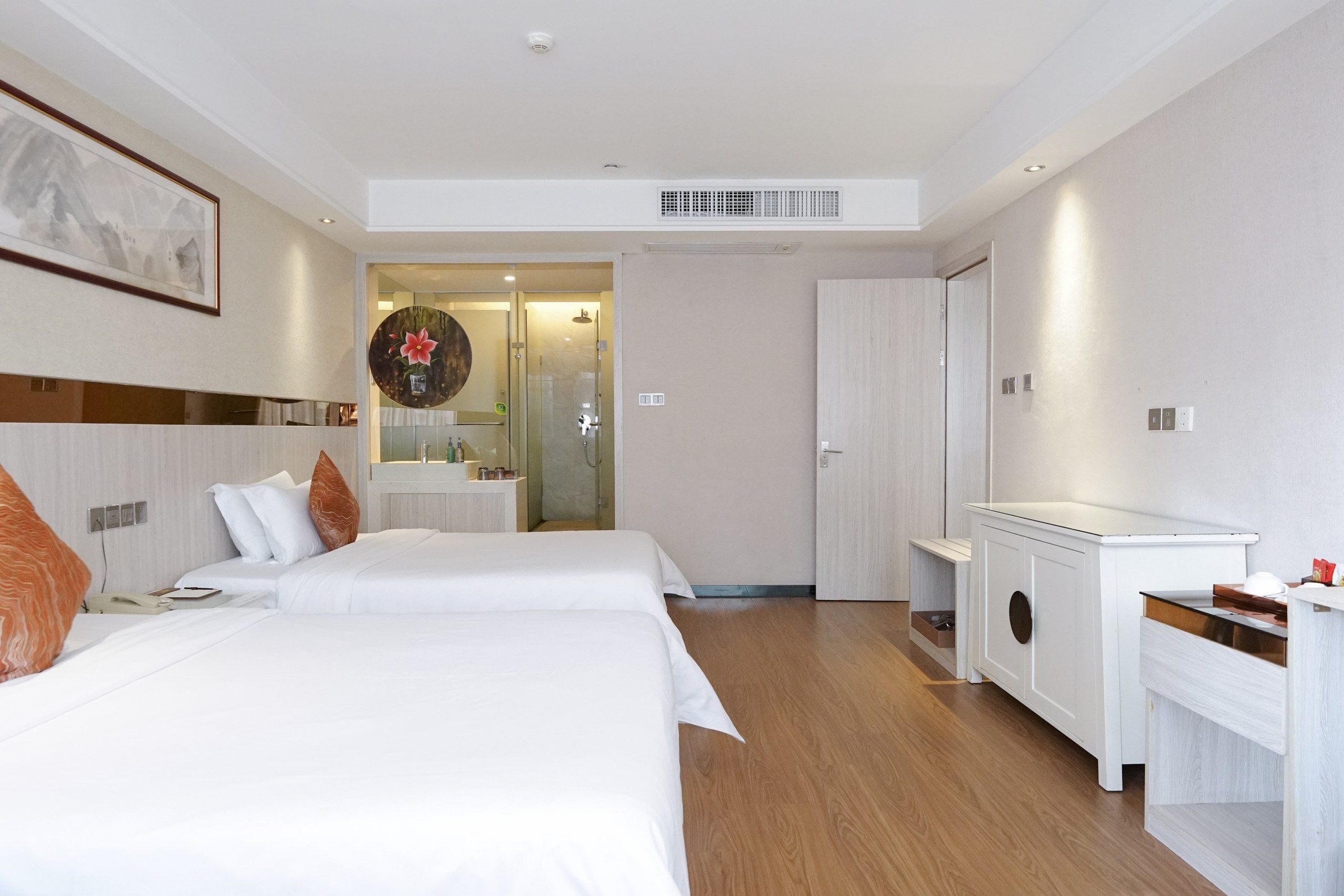 Habitación de hotel con dos camas, baño y kitchenette.