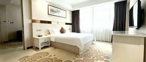 Une chambre d’hôtel équipée d’un lit, d’une table de chevet et d’un bureau avec un téléviseur à écran plat.