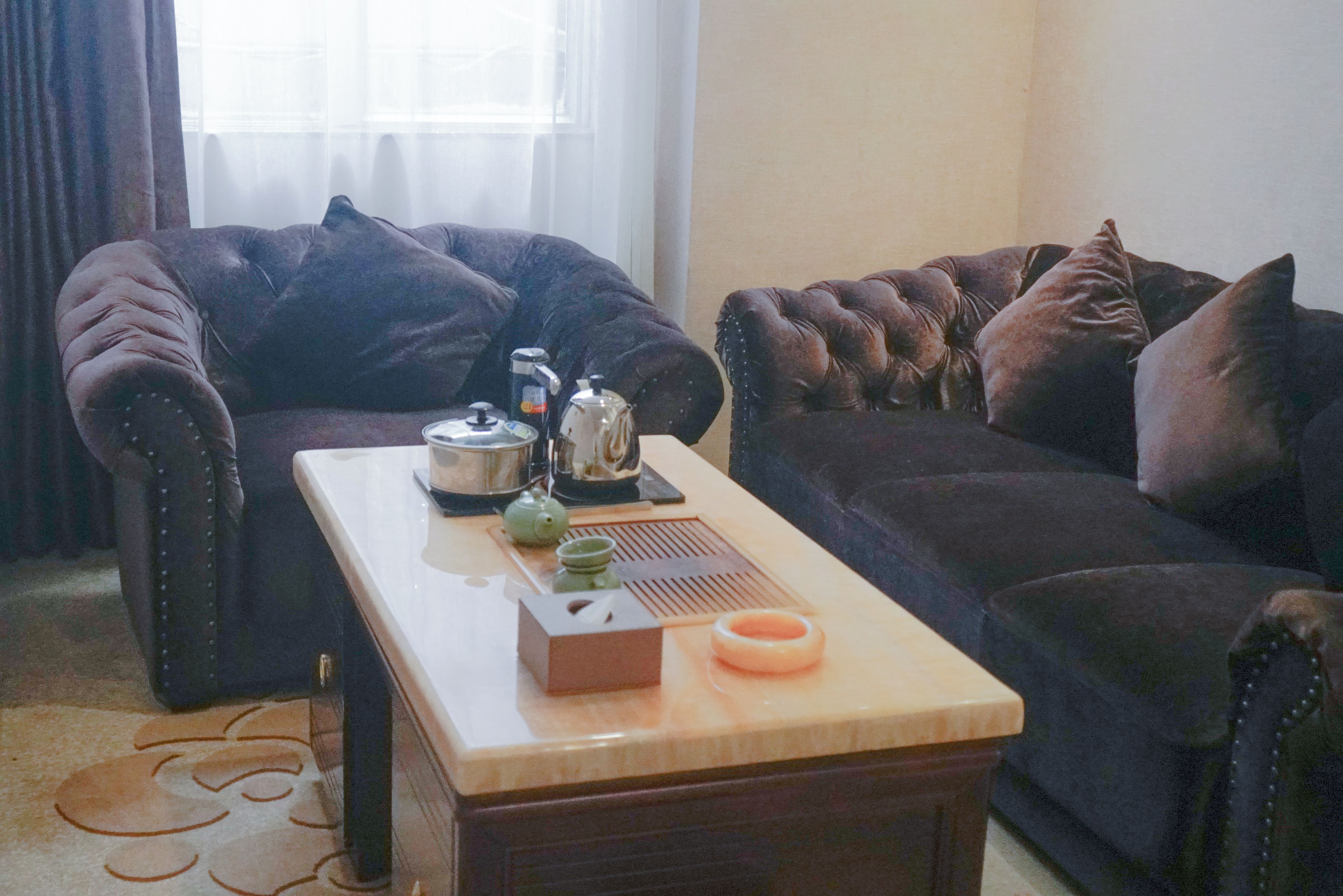 Una sala de estar con un sofá, una mesa de centro y una tetera.