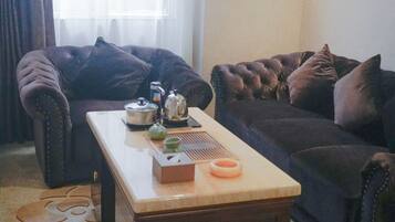 Una sala de estar con un sofá, una mesa de centro y una tetera.