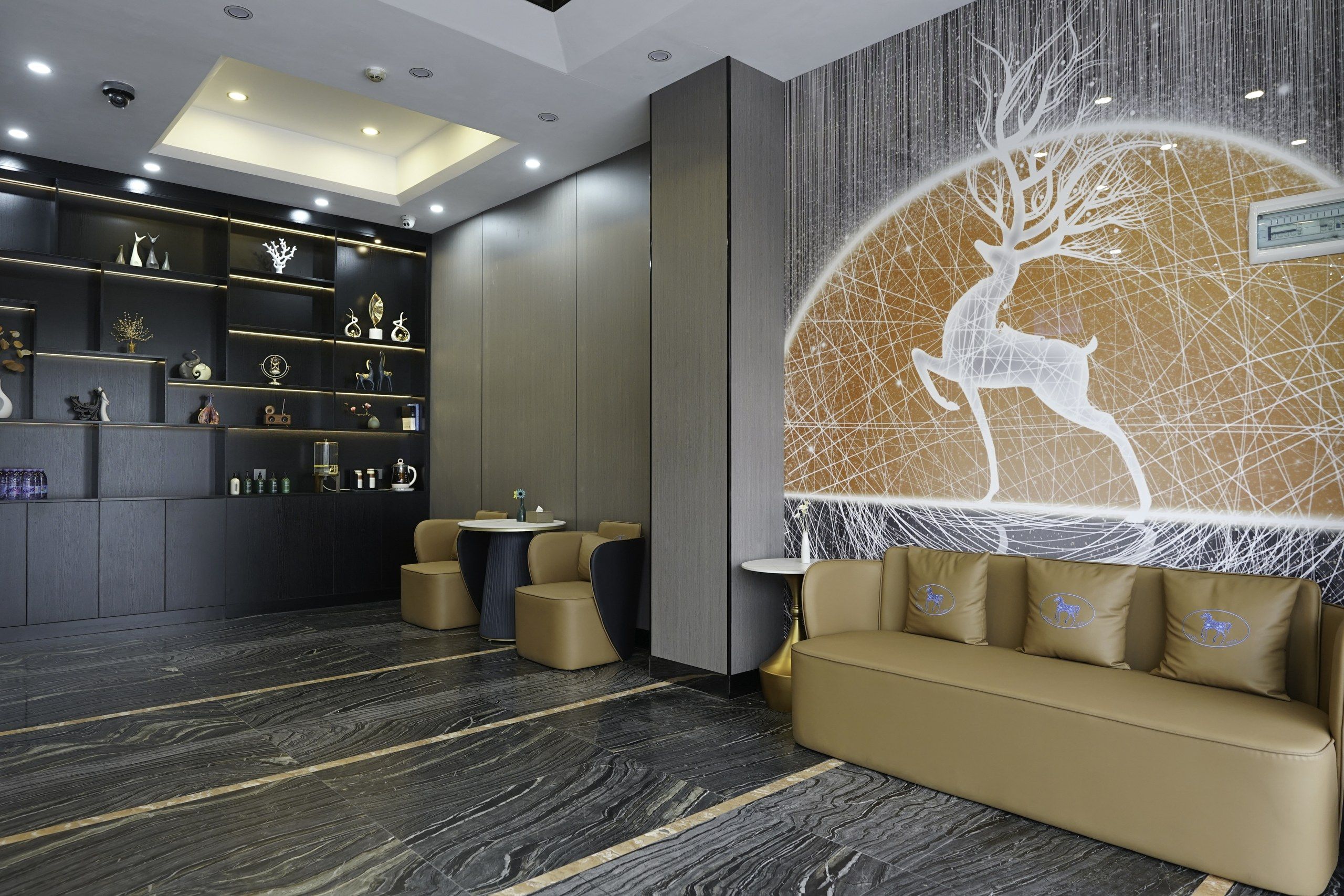 Un hall d’entrée moderne avec un canapé, une table basse et un mur décoratif orné d’un motif géométrique.