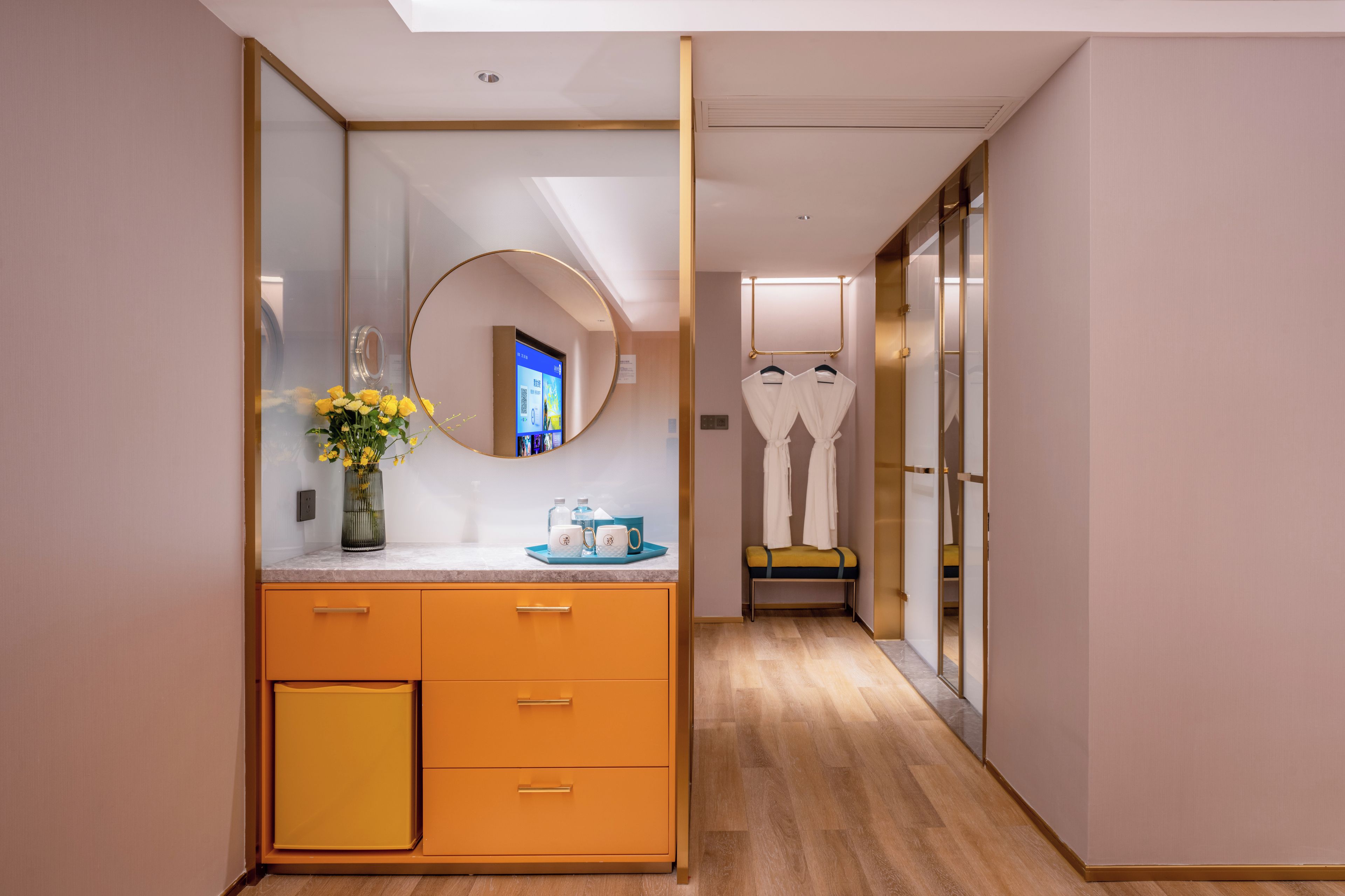Un baño moderno con tocador, espejo y una pequeña zona de estar con toallas.