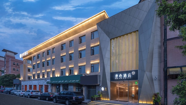 Um hotel com fachada moderna, vários andares e entrada destacada.