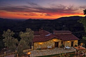 A stone house with a tiled roof, outdoor seating, and a view of the surrounding hills. - Villa Elsa, with a pool and breathtaking views of the Roman countryside (Lazio)