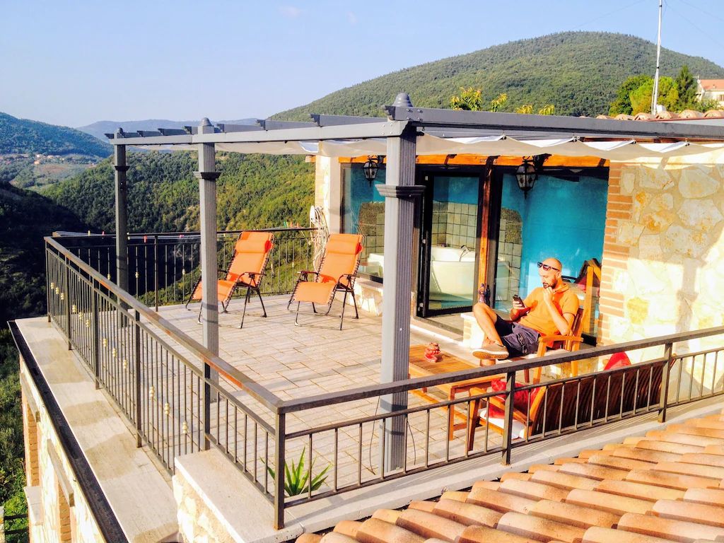 Une terrasse avec des sièges extérieurs et une vue sur un paysage montagneux.