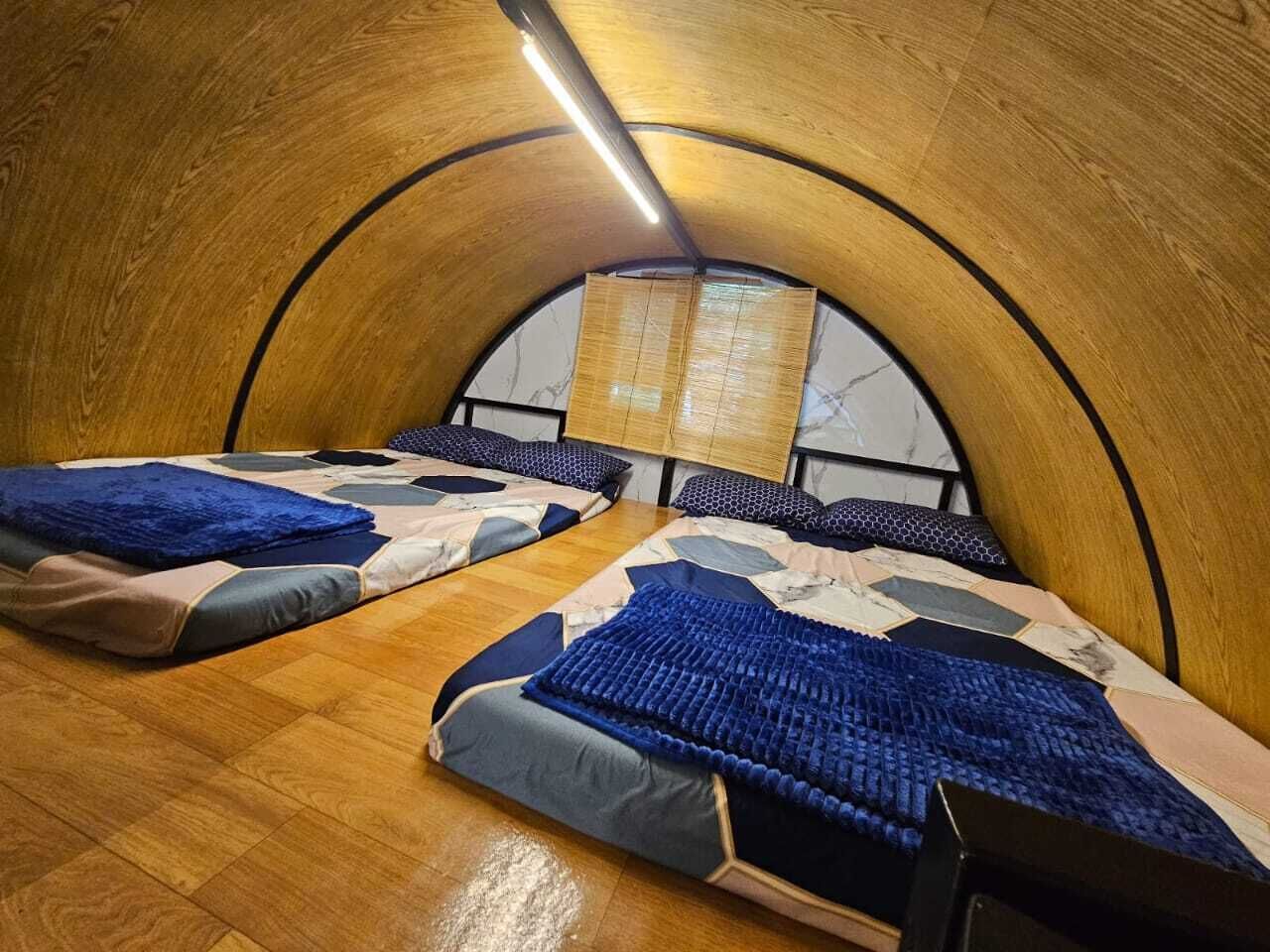 Une chambre avec deux lits, un plafond en bois et une fenêtre donnant sur un beau paysage.