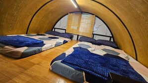 Una stanza con due letti, travi a vista in legno e una finestra con vista.