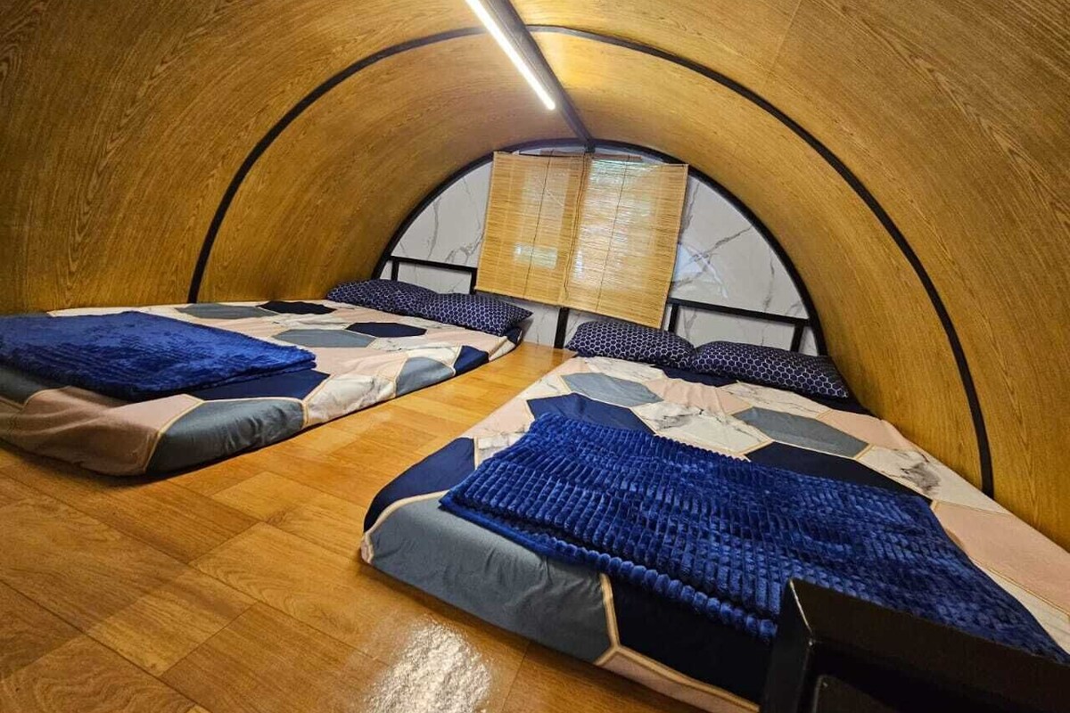 Une chambre avec deux lits, un plafond en bois et une fenêtre donnant sur un beau paysage.