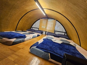 Une chambre avec deux lits, un plafond en bois et une fenêtre donnant sur un beau paysage.