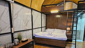 Una camera da letto moderna con un letto, un comodino e una testiera in legno.